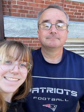 Mike and Sophia Adams stand in front of a brick wall.