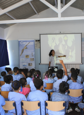 A student presenting in front of a young classroom