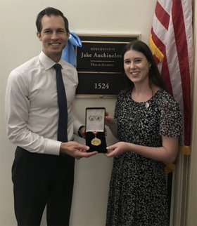 Madison Cable receives her gold medal from a congressman.