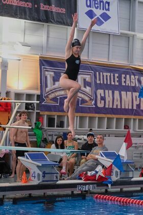 A woman jumps on a diving board