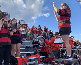 Delaney Hughes conducts the BSU Bear Band at a football game.
