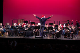 A man stands at the front of the stage with his hands up