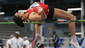 A woman jumps over a bar during a high jump event