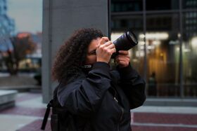 A woman holds a camera and takes a photo