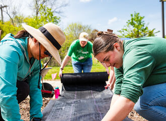 students and faculty working in the permaculture garden