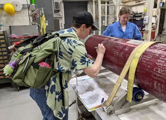 Abby Brown signs name on exterior of a red rocket