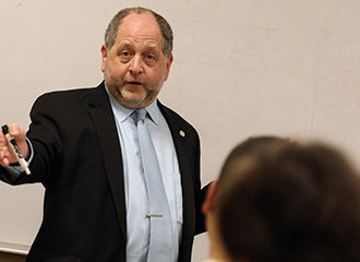 Dr. Aeon Skoble gesturing at a whiteboard