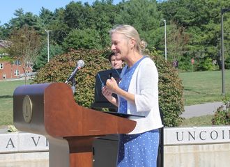 Dr Jo Hoffman speaking at a podium outdoors