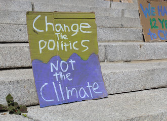 Protest sign on the steps of Boyden Hall, saying change the politics not the climate