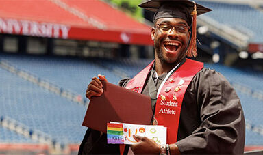 A student holds their diploma and envelope containing money.
