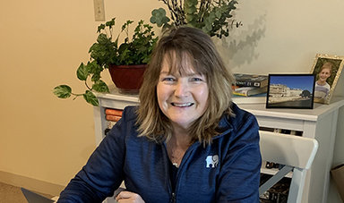 Jeanne Carey Ingle works at a table in her home.
