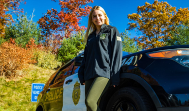 Sarah Carlozzi stands in front of a police cruiser