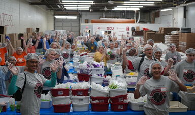 A group of people put together boxes of food
