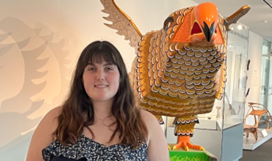 Brie stands in front of a bird sculpture at a local museum