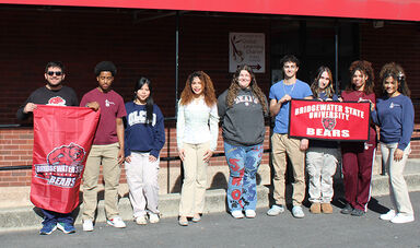 Several students stand in a line while holding BSU banners.