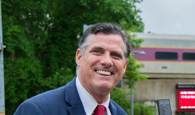 Frederick Clark poses for a photo along a campus sidewalk.