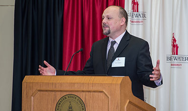 Dr. Brian Frederick speaks at a podium.
