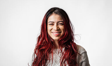 A woman with long hair smiles at the camera