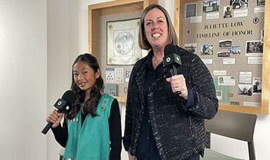 Mary-Jane Storm stands with a girl while both hold microphones