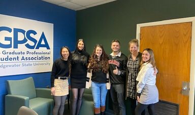 A group of people stand together smiling and looking at camera