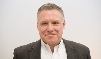 Headshot of Andrew Holman in front of a white background