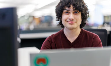 A young man smiles at the camera