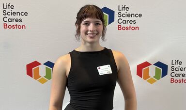A woman wearing a black dress smiles