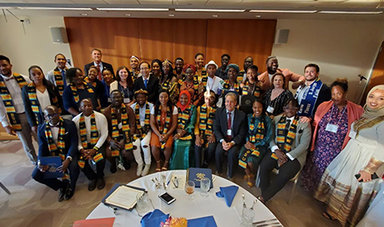 Mandela fellows and BSU staff stand in a semicircle behind a round table