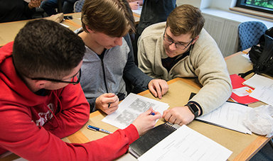 Three students work together on a math problem.