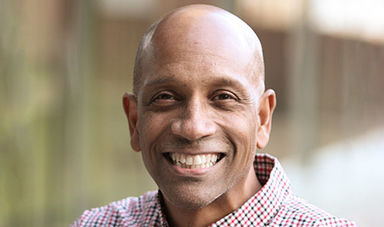 Headshot of Kevin McGowan standing in front of a glass wall