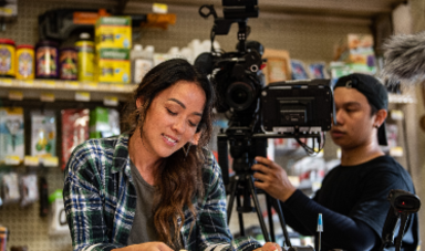 Patty Lee on the set of a tv show with a cameraman standing behind her