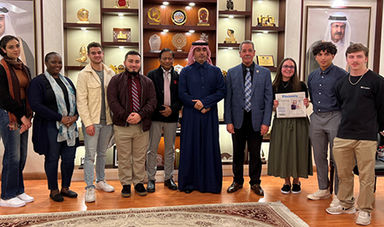 Students and faculty stand next to the editor of The Peninsula
