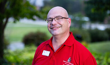 Headshot of Stratos Bonos standing in front of landscaping.
