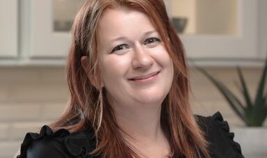 A woman with red hair smiles at the camera