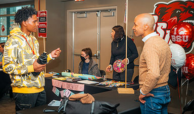 A student and professor converse at a transfer welcome event.