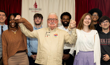 Students pose for a group photo and hold hands with President Walesa.