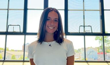 Nora Sperling stands in front of windows.