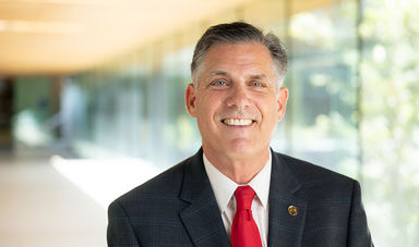 BSU president Fred Clark smiling for the camera in a sunlit corridor