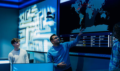 A student watches a faculty member demonstrate the features of BSU's cyber range