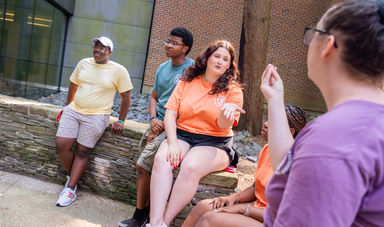 Students talking animatedly outside an academic building on BSU's campus