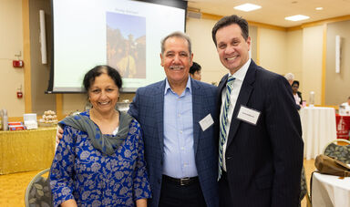 Dr. Uma Shama, Dr. Jabbar Al-Obaidi, and Mr. Vinny deMacedo pose and smile for the camera at the Global Engagement Day celebration