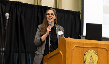 Sarah Sibley speaking at a podium at Global Engagement Day