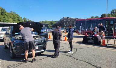 BSU volunteers inspecting a student's vehicle on Student Car Care Day