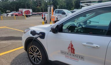 A BSU electric vehicle charging at the operations lot