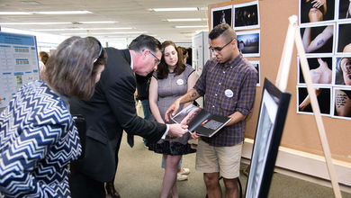 BSU student presenting research to President Clark at spring symposium
