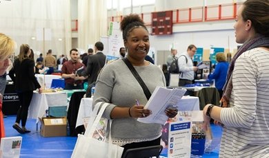 A student meets with an employer at the Job and Internship F