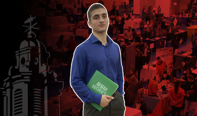 Michael Hopkins holds a green folder in front of a job fair background 