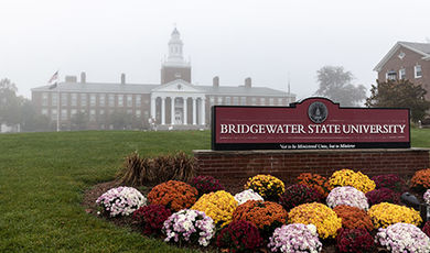 photo of Boyden Hall from the front of the quad showing BSU sign with different colored mums in front of it