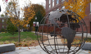 Globe sculpture in front of Boyden Hall with U.S. flag