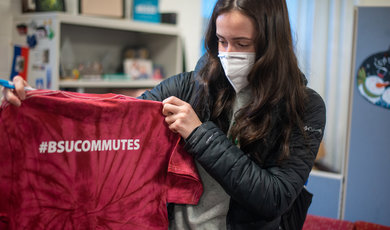 Student holding t shirt with #BSUCommutes written on it